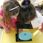Children from A Quiet Forest Daycare and Preschool using a microscope.